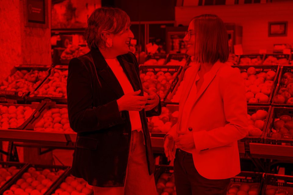 Dos mujeres conversando en la sección de frutas y verduras de un supermercado EROSKI.