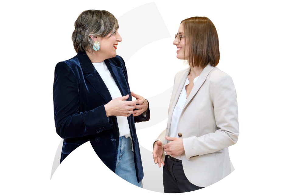 Dos professionals conversant i somrient.