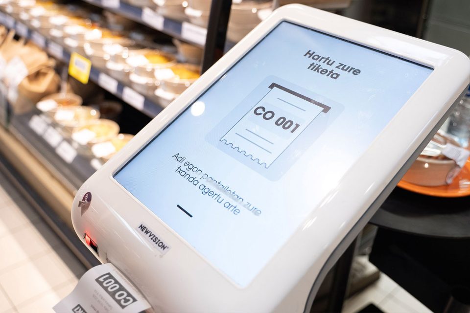 Pantalla de torns en supermercat mostrant tiquet d'espera en la secció de menjar preparat.